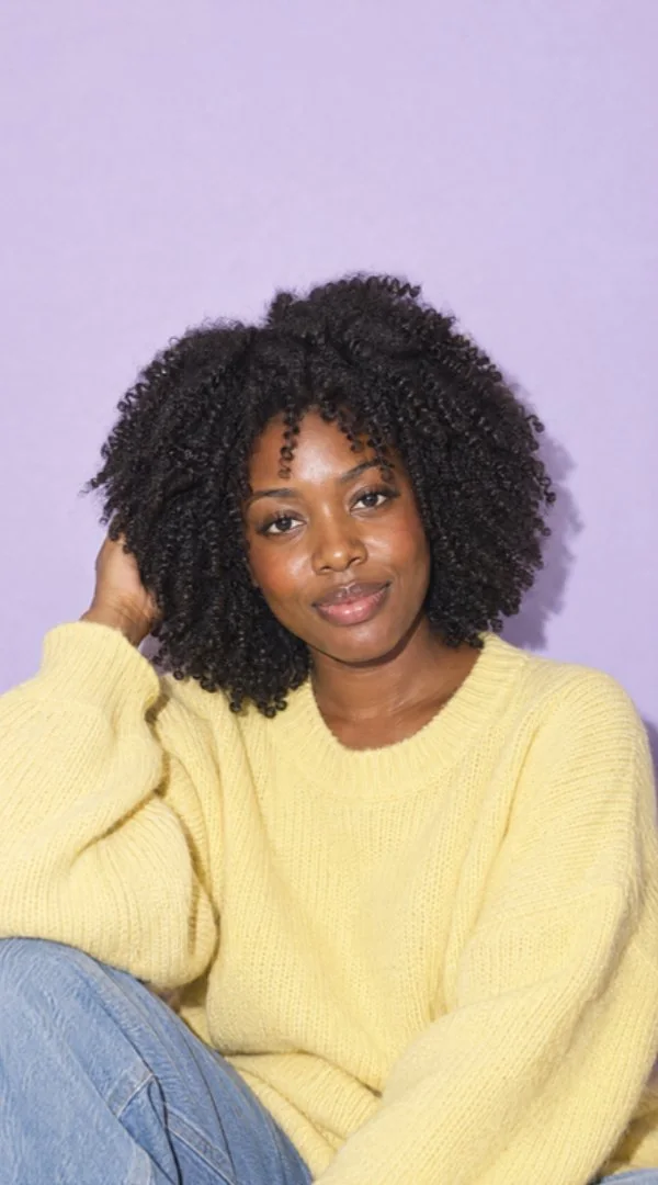 Woman with 4B coils in a butter-yellow knit