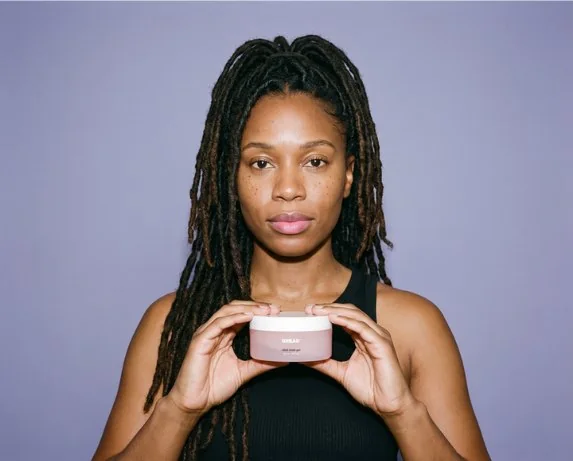 Woman with locs holding the slick-hold gel