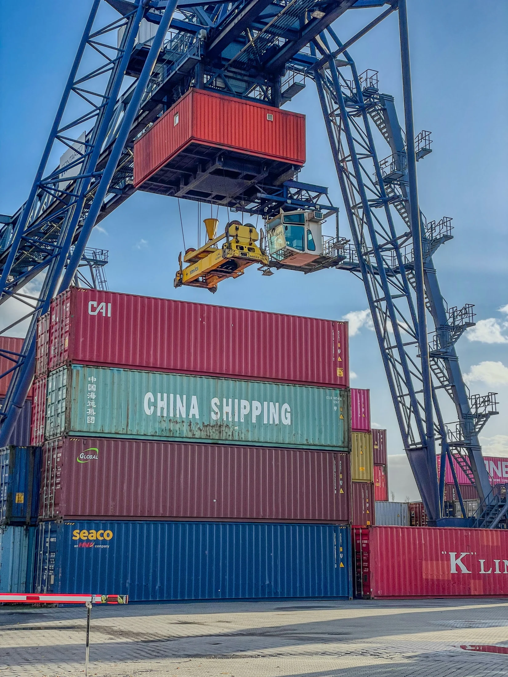 Gantry crane lifting a shipping container at a terminal
