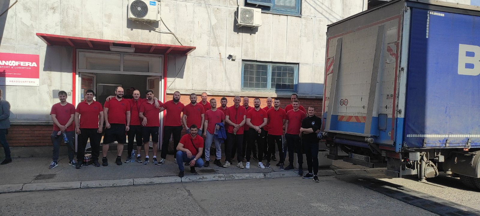 19 jakih momaka stoje spremnih za rad pored kamiona za selidbea za sel