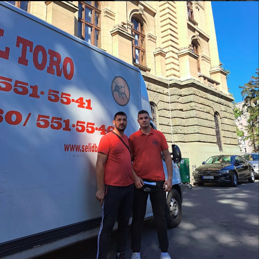 Dva jaka momka, zaposlena u agenciji za selidbe stoje ispred kombija