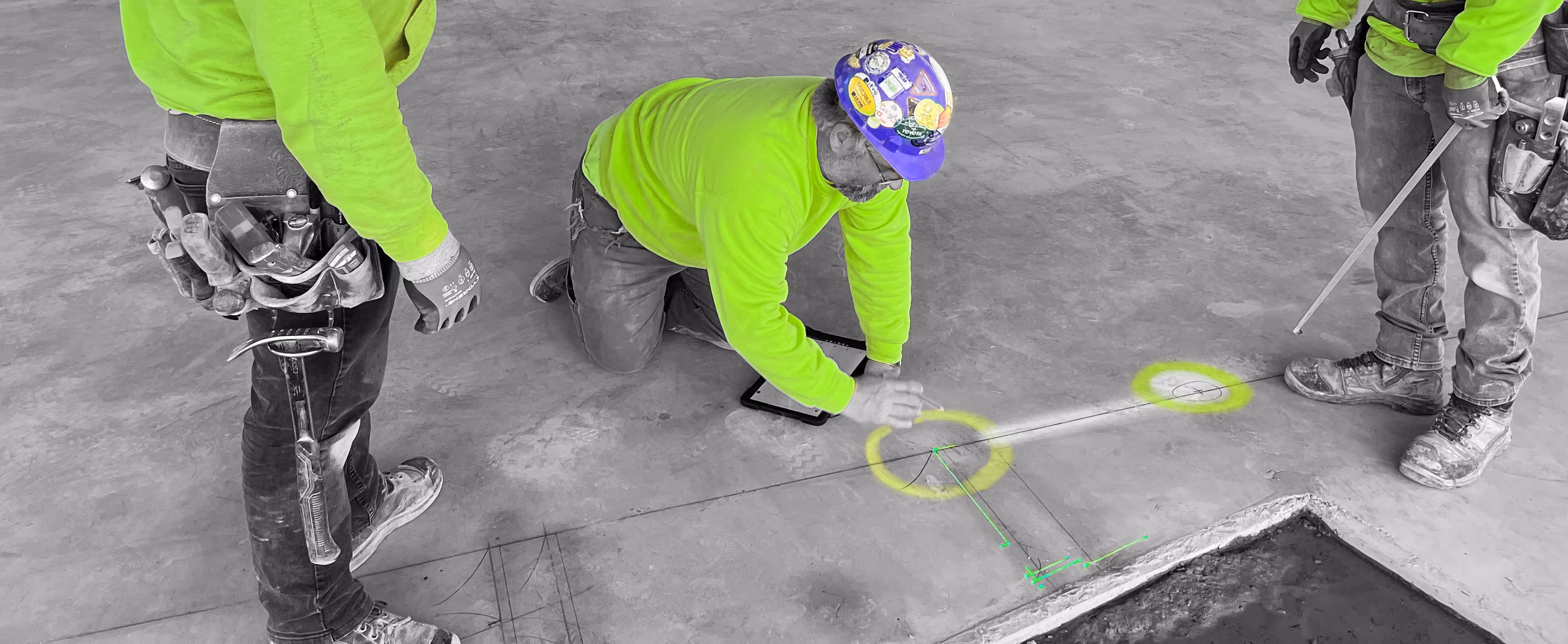 Three construction workers marking the floor using laser projection