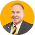 Smiling middle-aged man wearing a dark suit and yellow-striped tie against a yellow background.