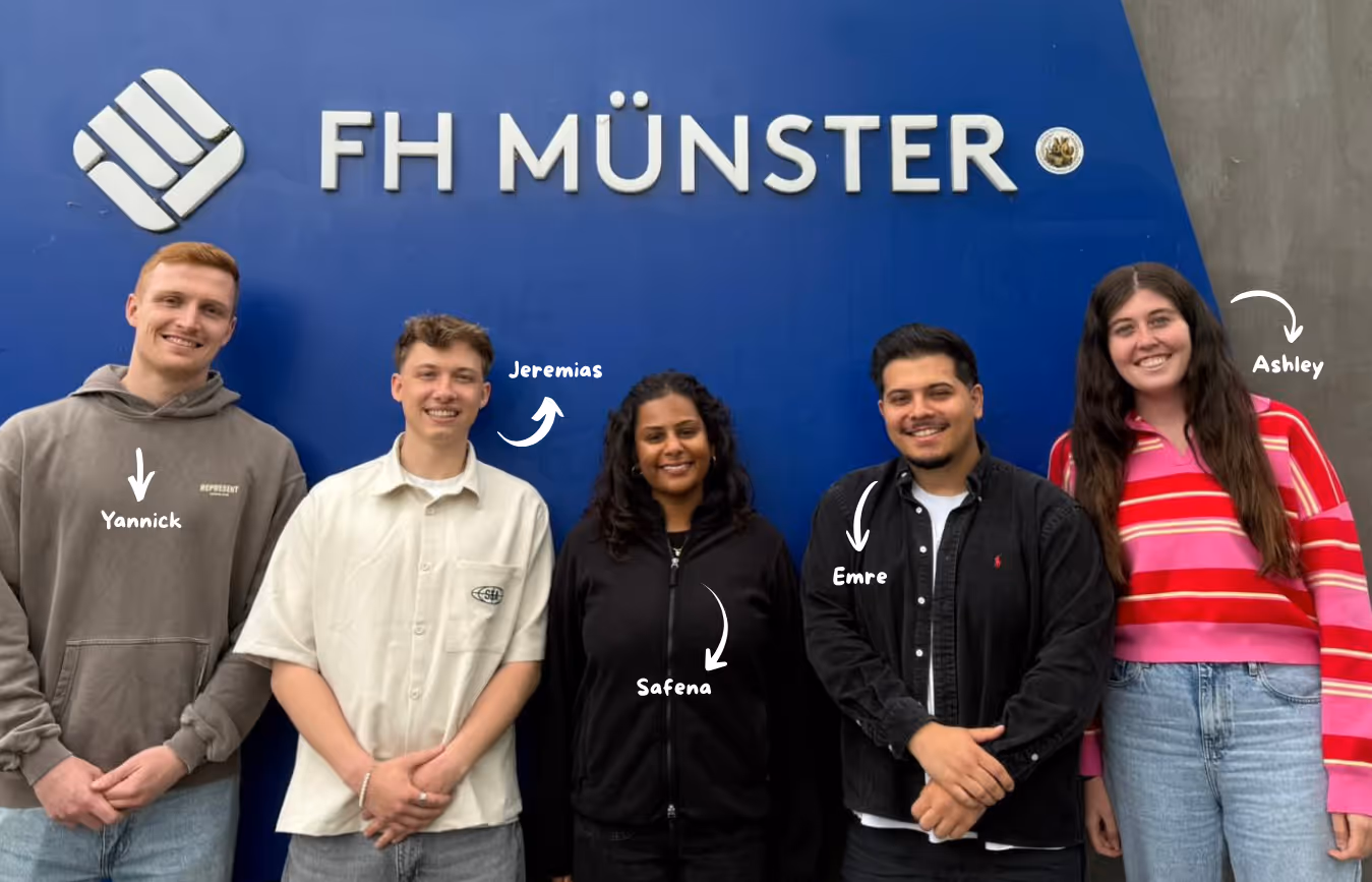 Group photo infront of FH Münster Logo, from left to right: Yannick, Jeremias, Safena, Emre, Ashley