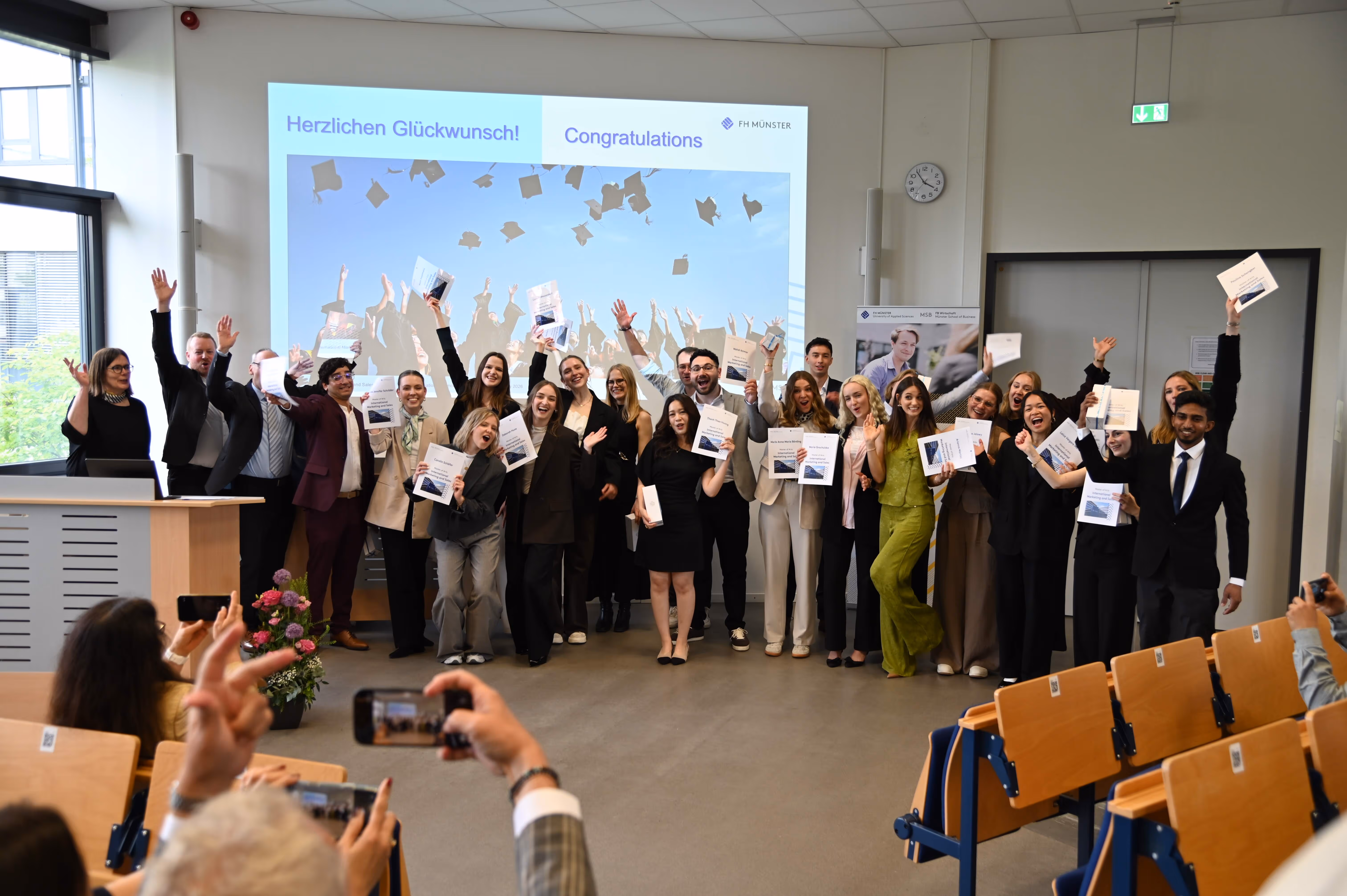 IMS graduates celebrating together after receiving their Master's certificates at FH Münster.