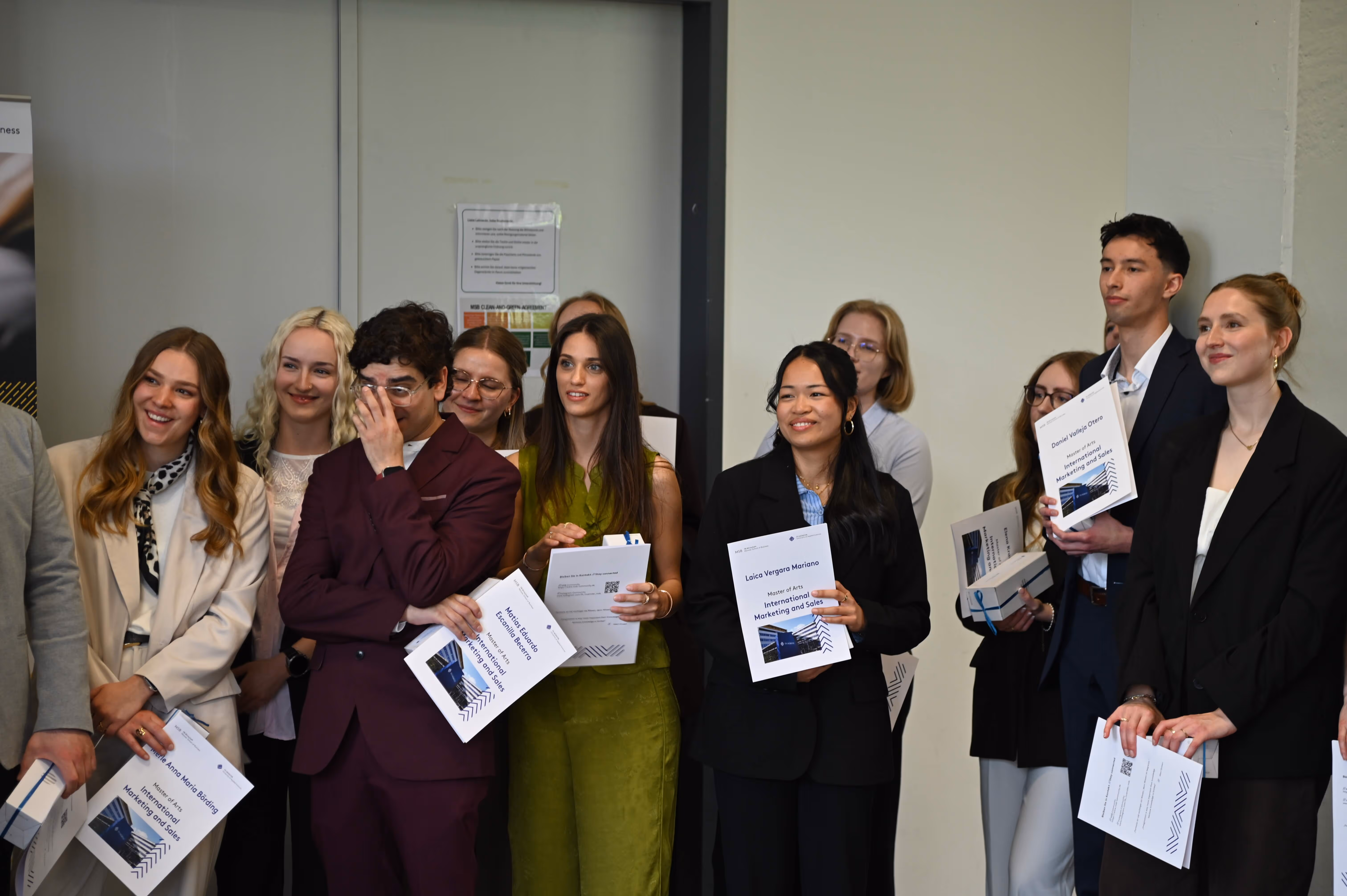 IMS graduates holding their certificates and celebrating their academic achievements.
