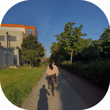Student cycling through Münster on a sunny day, showcasing the city's bike-friendly lifestyle.