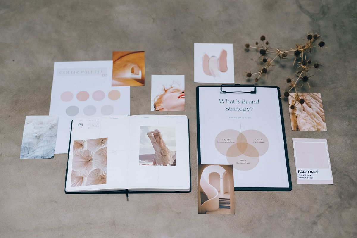 Branding assets and documents laid down on a concrete floor.