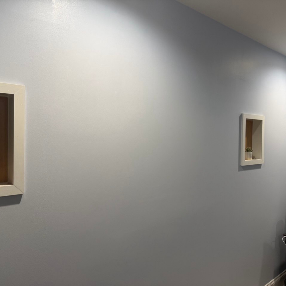 Finished wall after interior window removal and drywall repair in Naperville IL with new trim and painted surface.