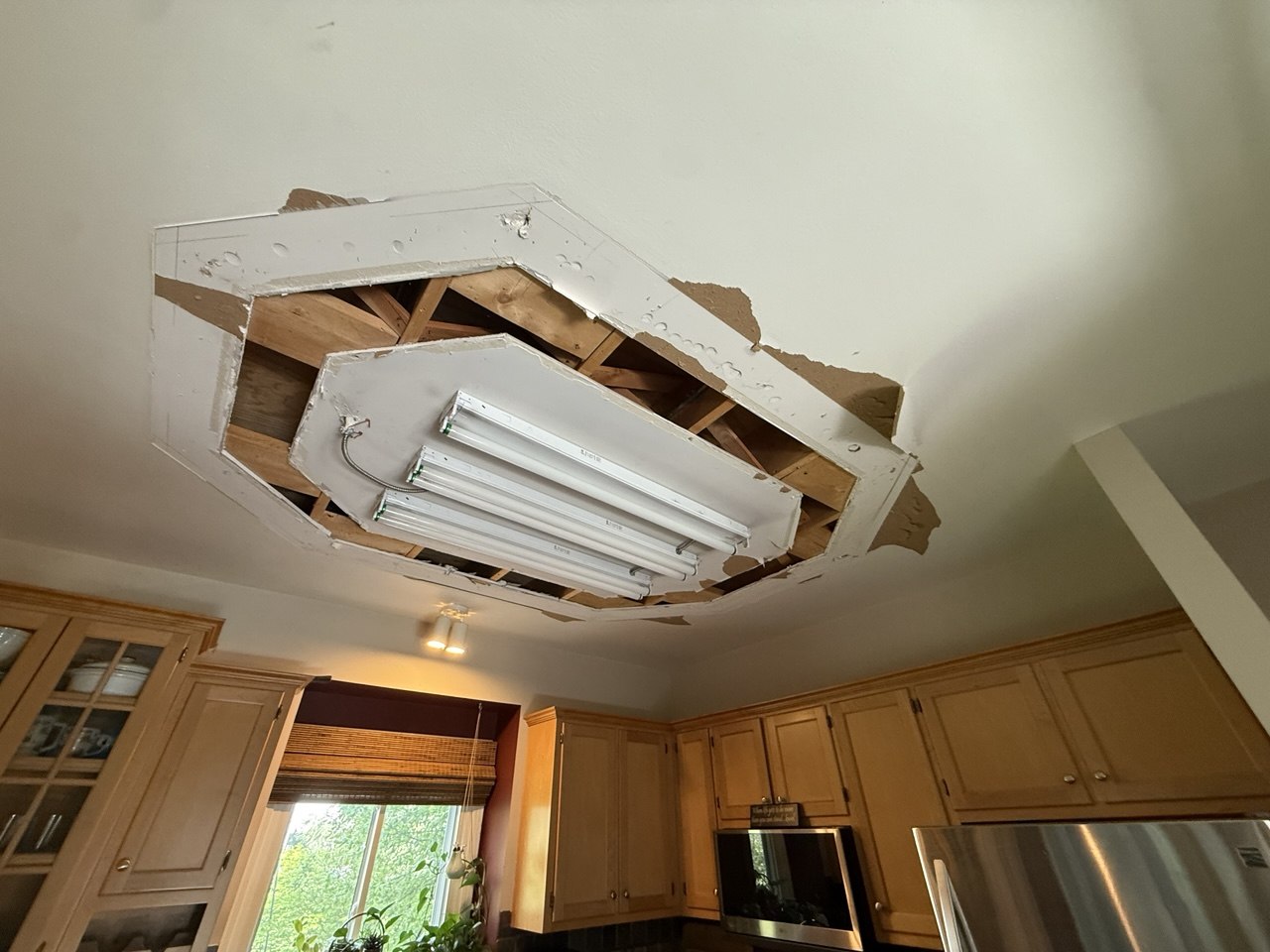 Damaged kitchen ceiling after removal of recessed light fixture before drywall repair in Aurora IL
