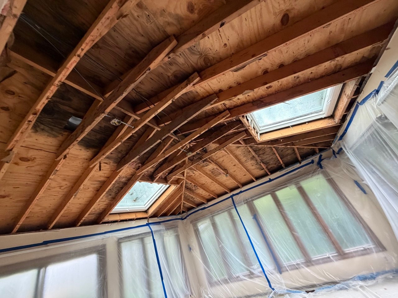Exposed ceiling framing around two skylights before drywall replacement in Batavia, IL