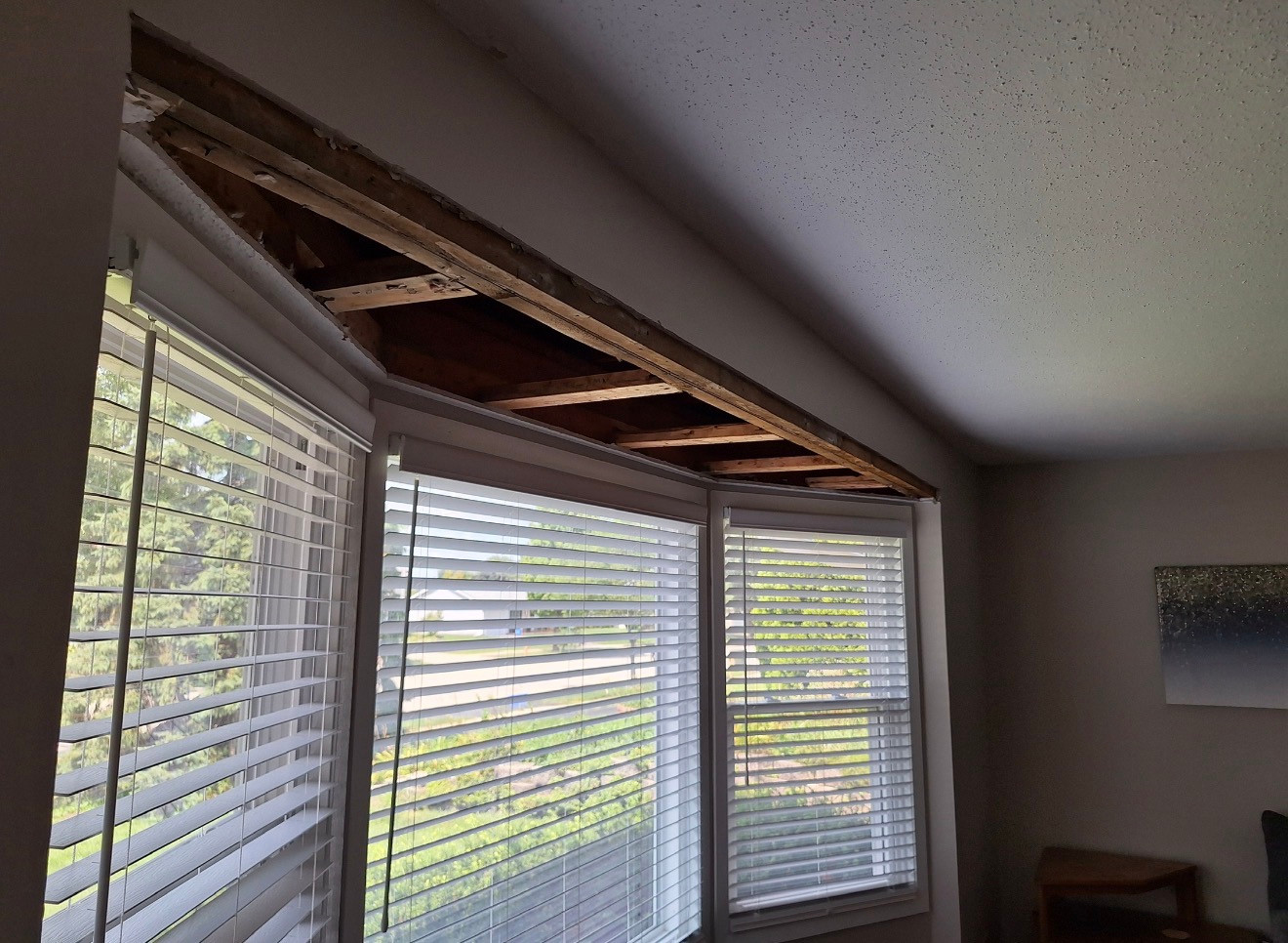 Open soffit above bay windows with exposed timber before repair in Bolingbrook, IL