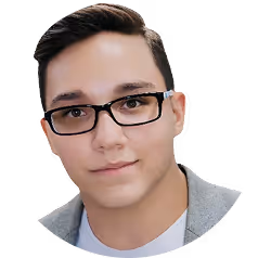 Young man with short dark hair and black glasses wearing a light gray jacket and white shirt.