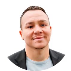 Man with short hair wearing a black blazer and a light-colored shirt smiling slightly against a transparent background.