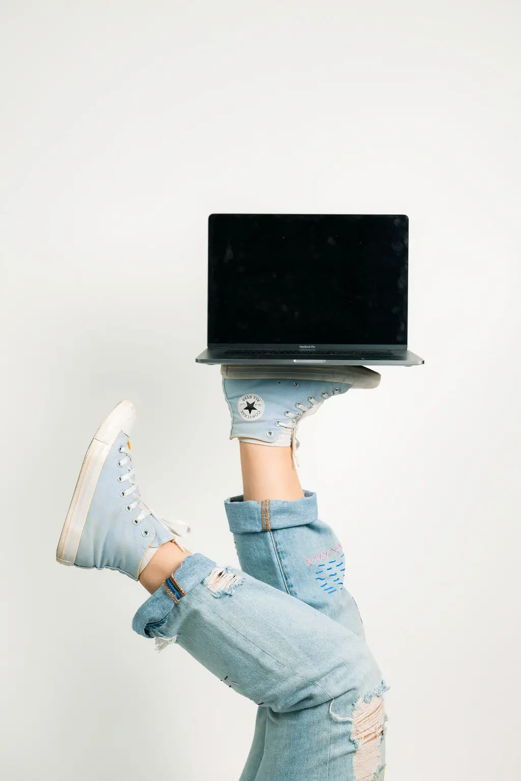 Laptop being balanced on someone's foot