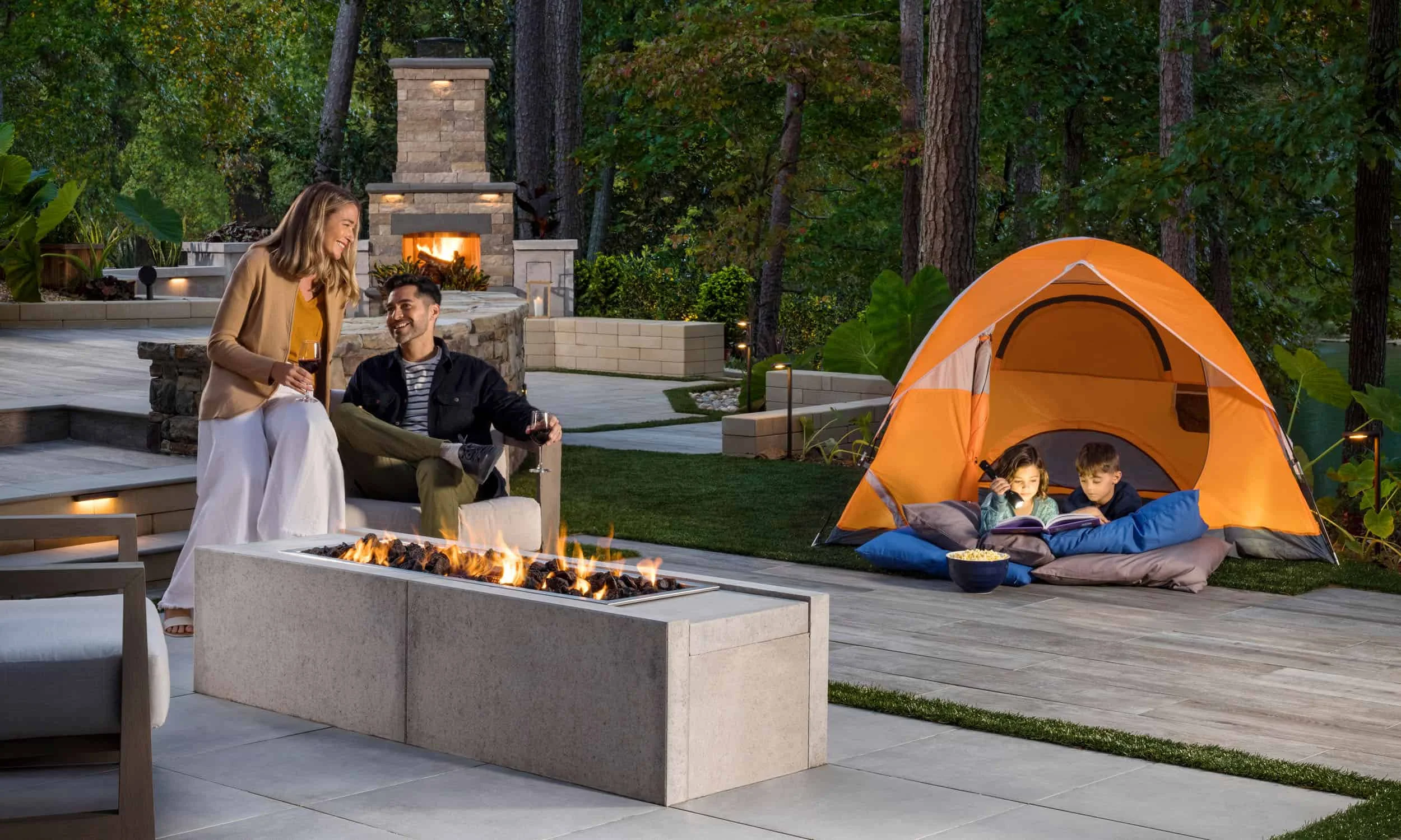Belgard promotion image of a family outside enjoying their patio while children play in a tent