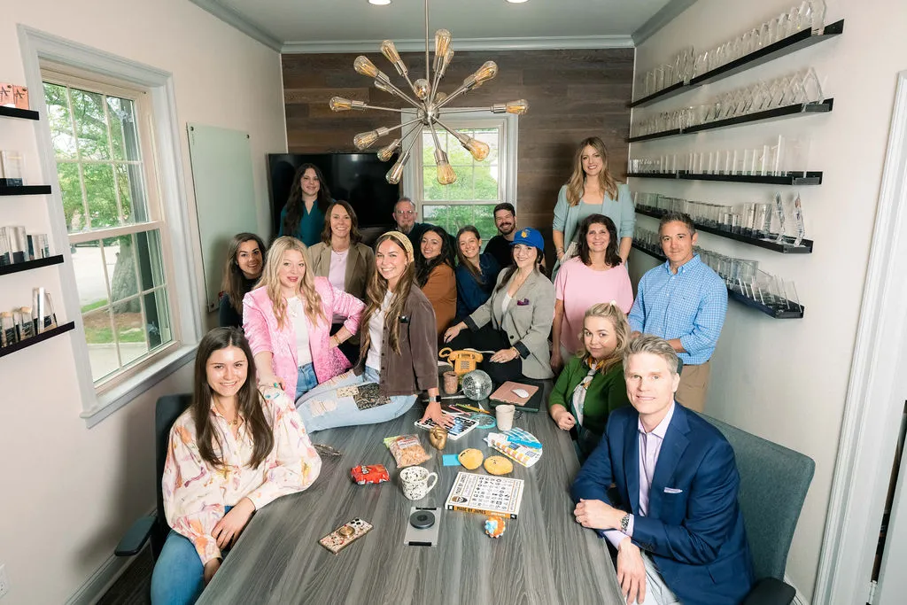 The MESH team gathered around a conference table for a group photo