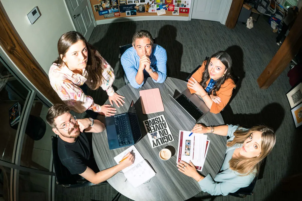 An overhead view of six team members working around a round table