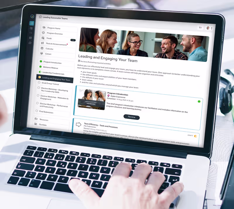 Laptop screen showing an online course interface titled 'Leading and Engaging Your Team' with course modules and a hand on the keyboard.
