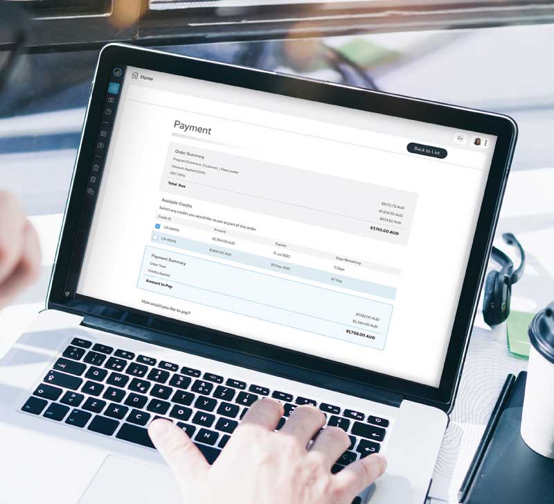 Person using a laptop displaying a payment summary page with order details and available credits.