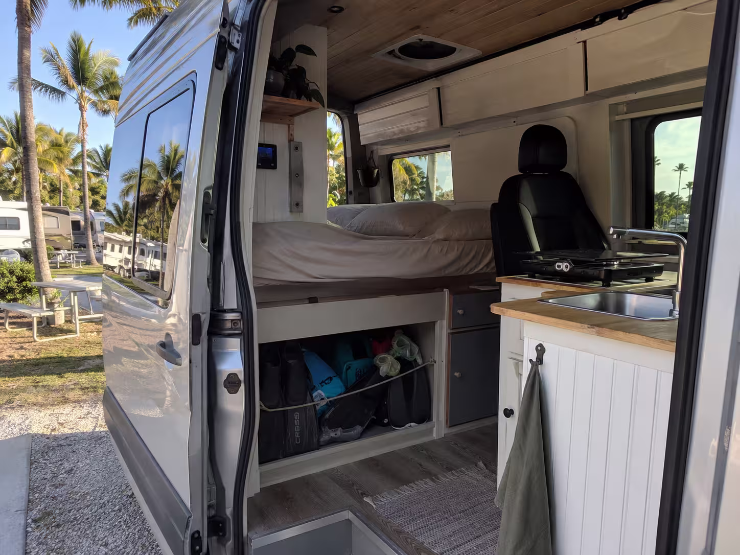 Camper van rental interior with rear bed and galley