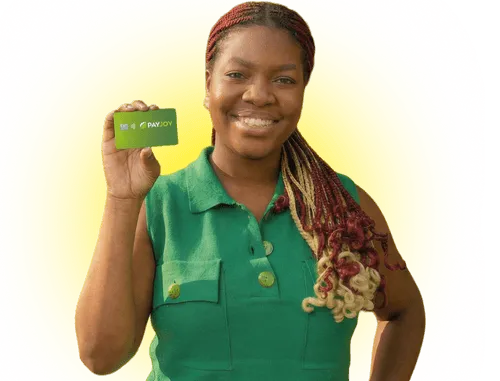 Smiling woman with red and blonde braids holding a green PayJoy card against a yellow background.
