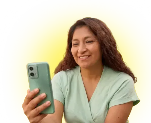 Smiling woman with curly hair looking at her smartphone against a bright yellow background.