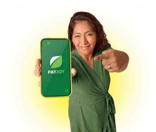 Woman in green dress smiling and pointing at a smartphone showing the PayJoy app logo on yellow.