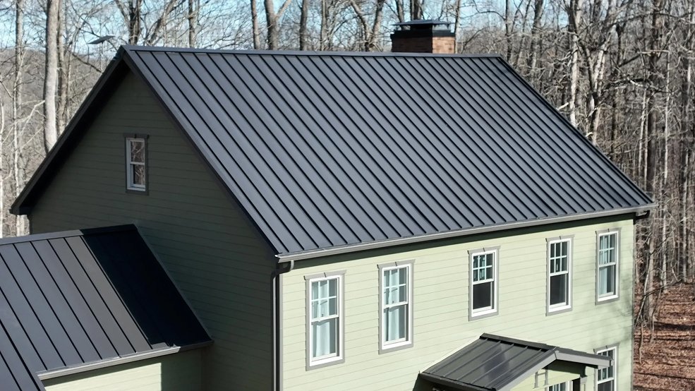 Full elevation of a dark bronze standing seam metal roof on a farmhouse in Columbia, Tennessee