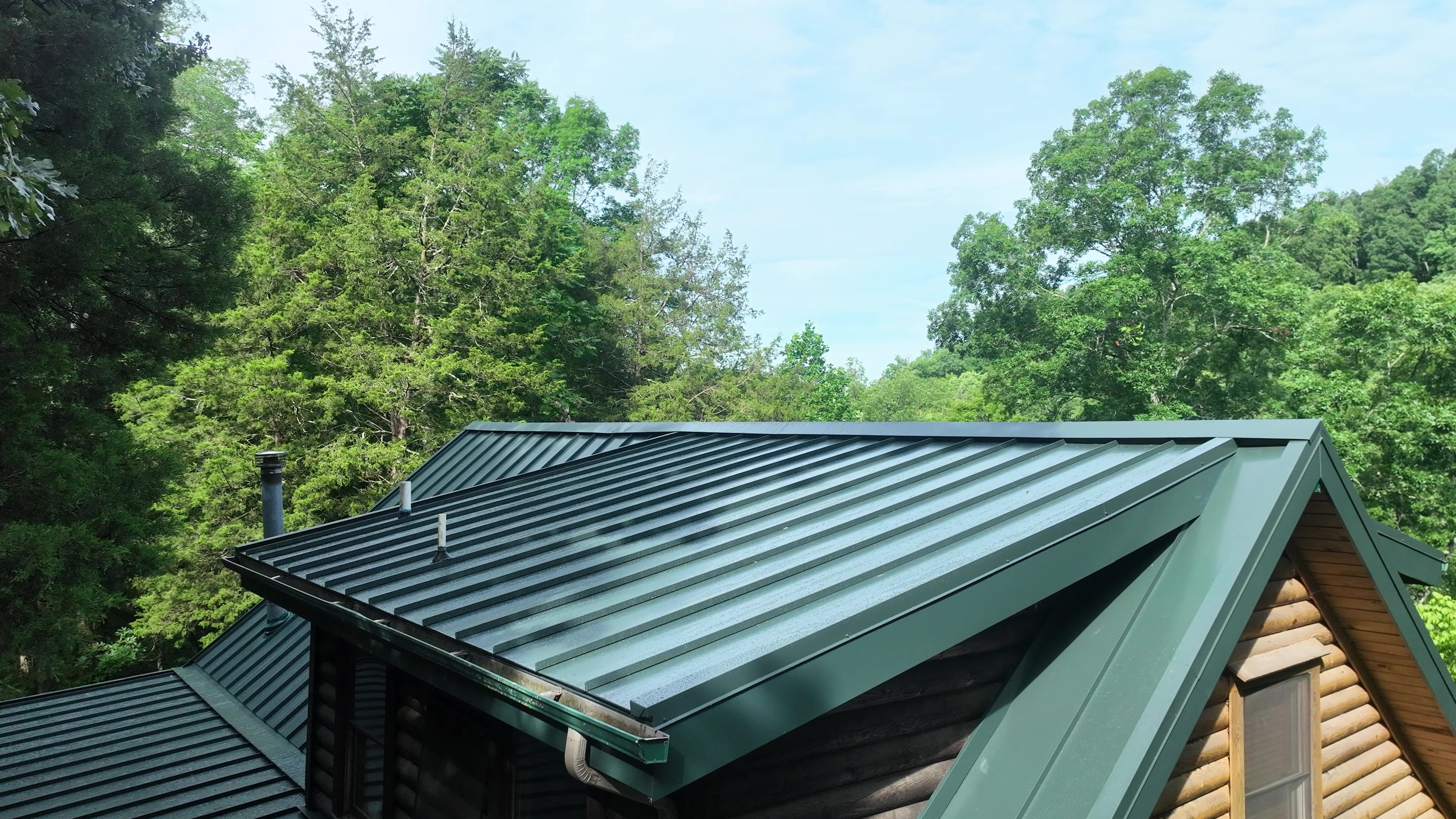 Aerial view of a Hartford Green standing seam metal roof on a log cabin in Cookeville, Tennessee