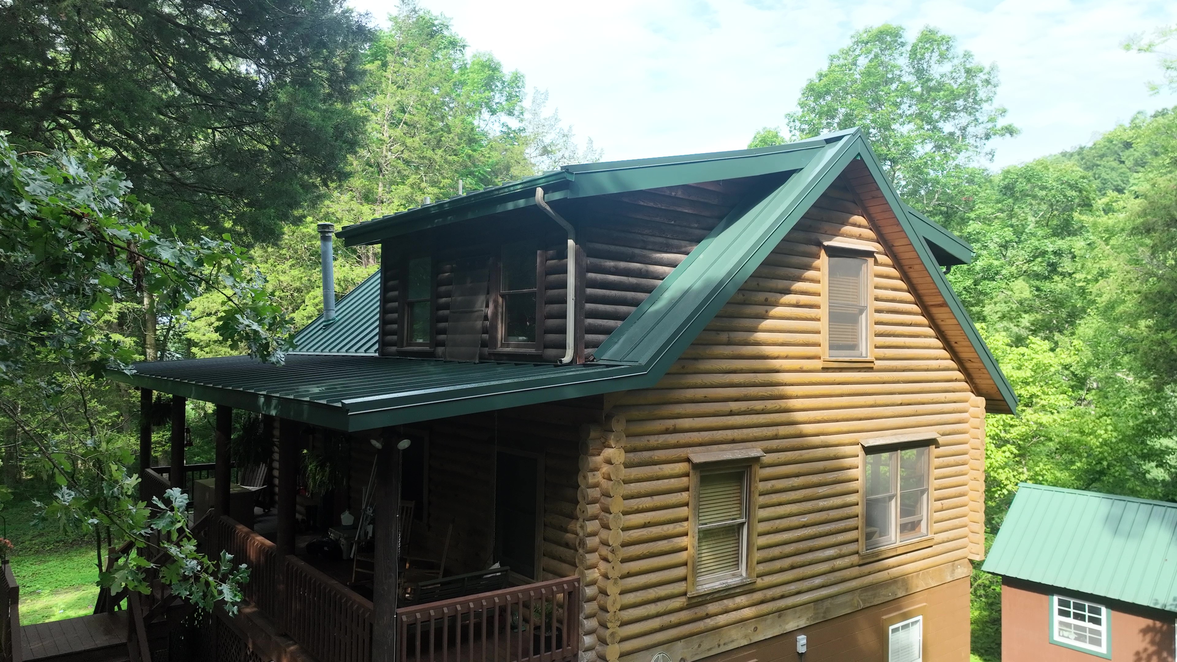 Drone view of a Hartford Green standing seam metal roof on a log cabin in Cookeville, TN