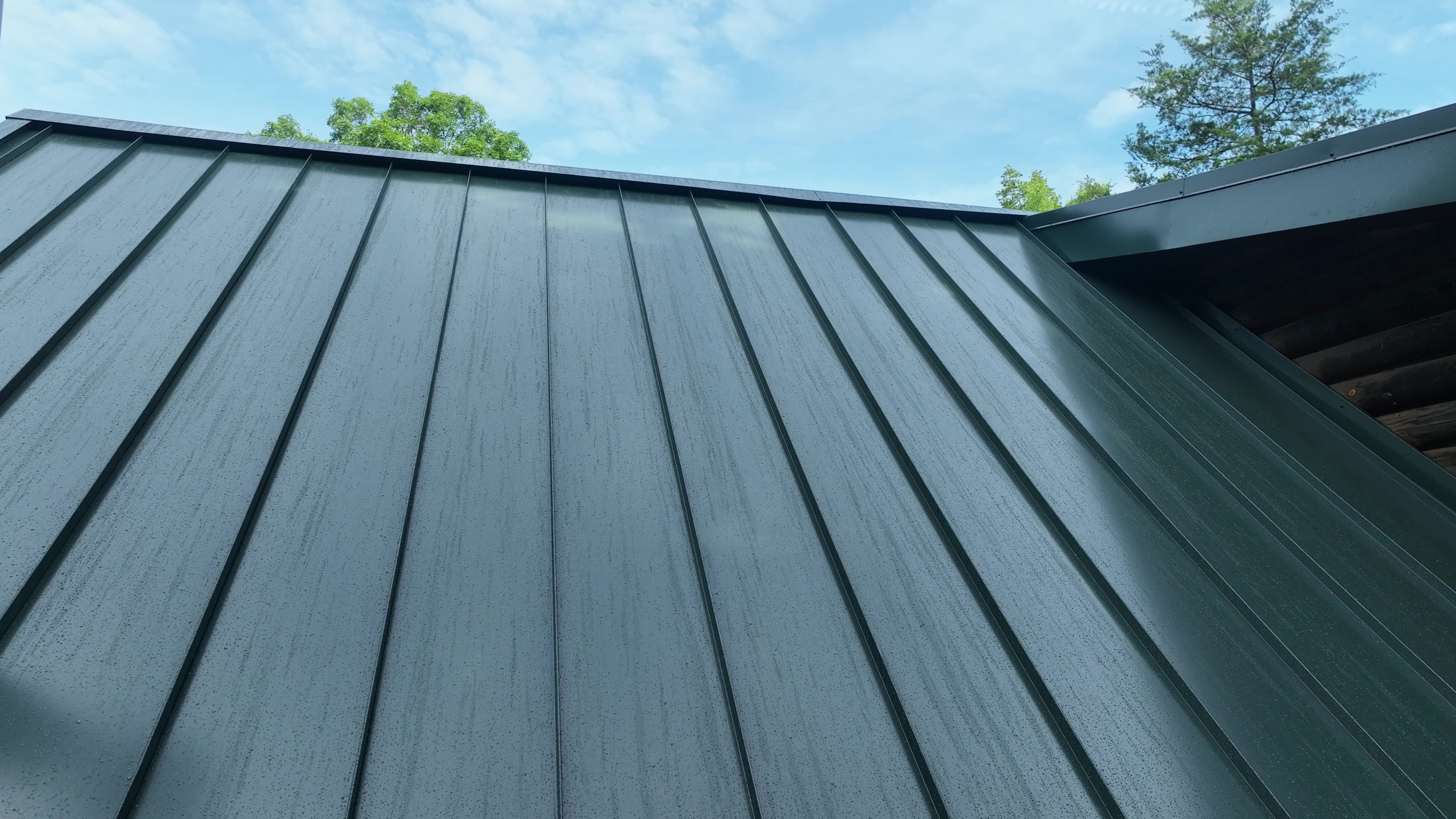 Drone view of a Hartford Green standing seam metal roof and treeline in Cookeville, TN