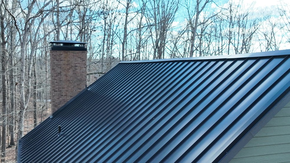 Rear elevation of a dark bronze standing seam metal roof on a farmhouse in Columbia, TN