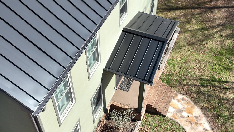 Completed dark bronze standing seam metal roof on a farmhouse in Columbia, Tennessee