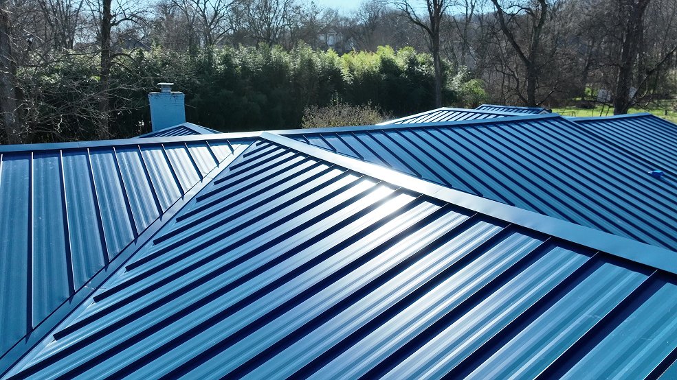 Side view of a royal blue standing seam metal roof on a mid century home in Nashville, TN