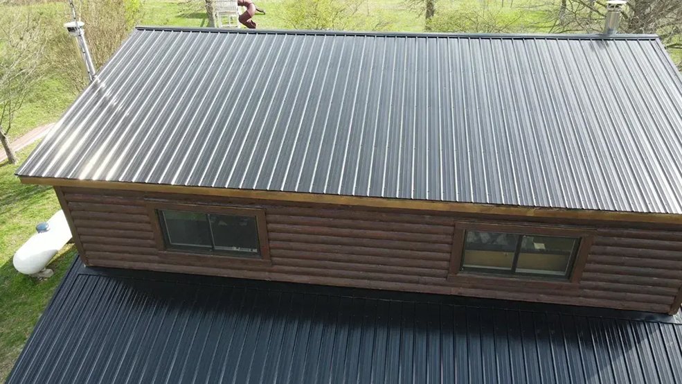 Black classic wave panel metal roof on a log cabin in Sparta, Tennessee
