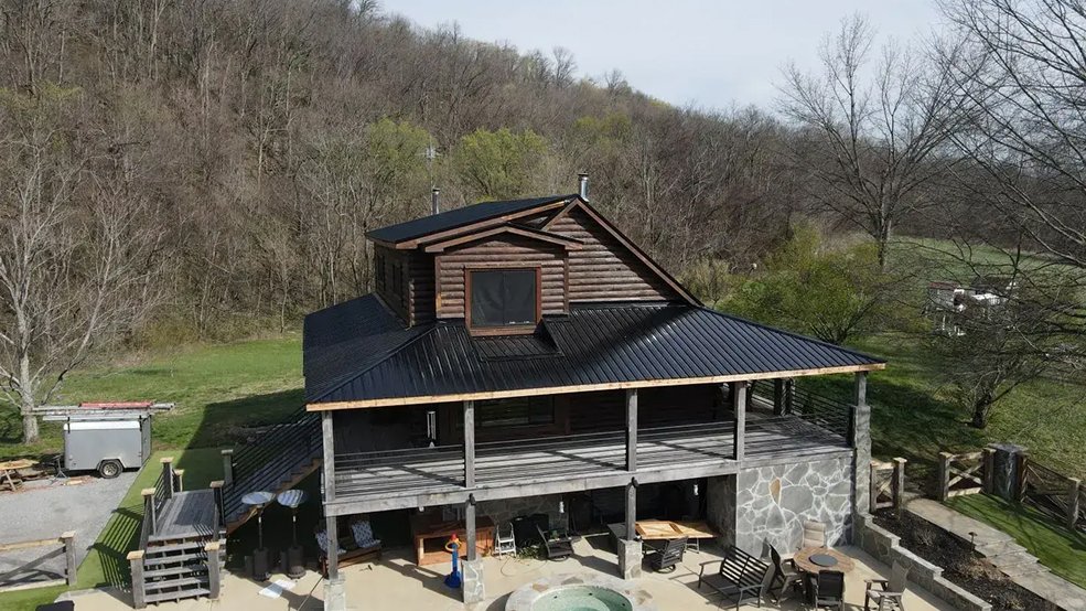 Black classic wave panel metal roof on a log cabin porch in Sparta, Tennessee