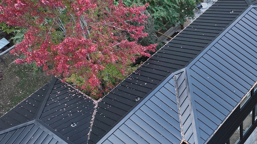 Black standing seam metal roof on a forest home in McMinnville, Tennessee