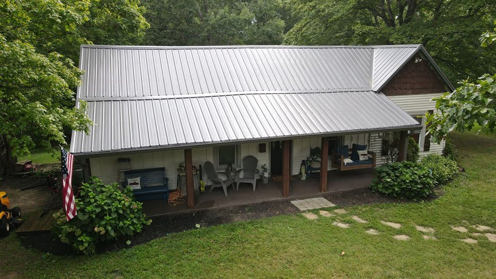 Silver classic panel metal roof on a forest home in Centerville, Tennessee
