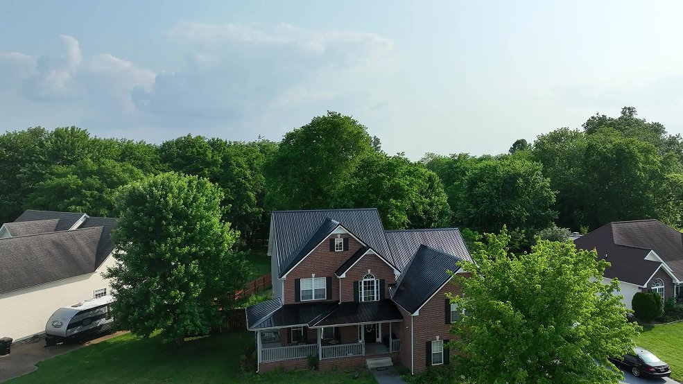Black classic panel metal roof over a brick home entry in Hendersonville, Tennessee
