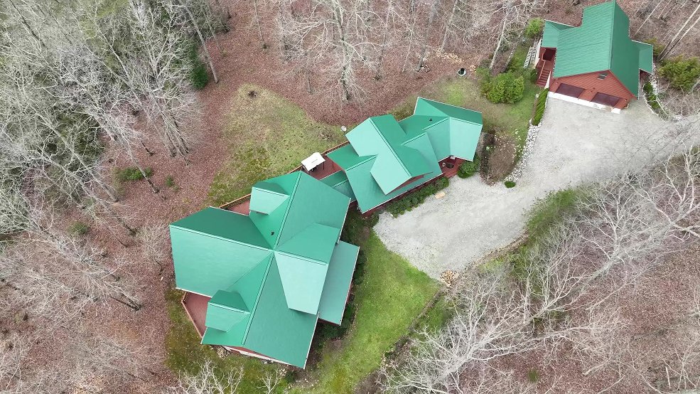 Green classic panel metal roof on a forested home in Manchester, Tennessee