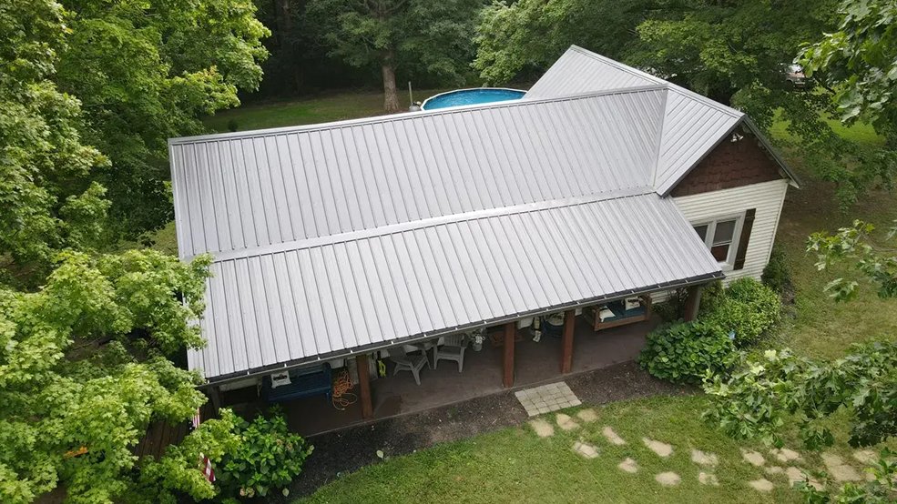 Silver classic panel metal roof among trees in Centerville, Tennessee