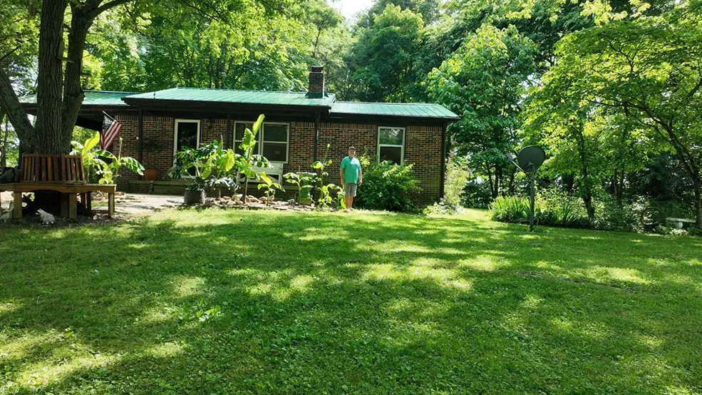 Silver classic panel metal roof on a forest home in Centerville, TN