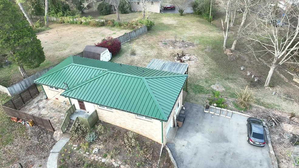 Green standing seam metal roof and front elevation of a ranch home in Goodlettsville, Tennessee
