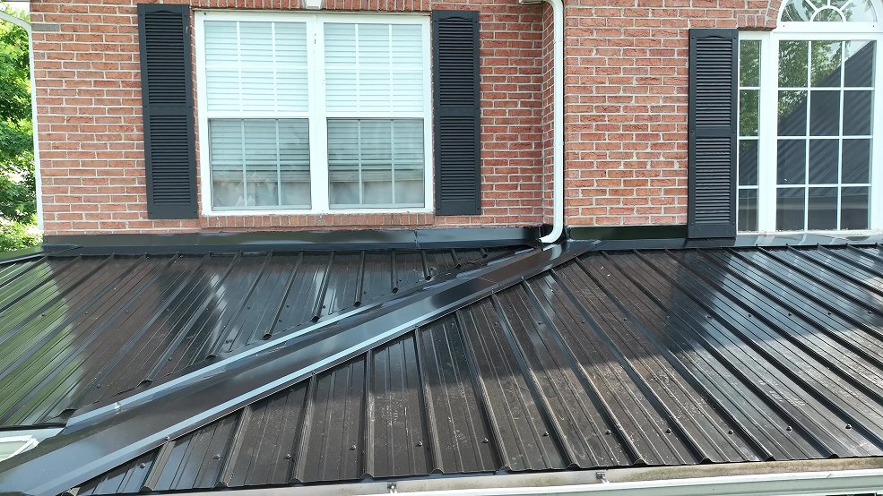 Black classic panel metal roof and gutter line on a brick home in Hendersonville, Tennessee