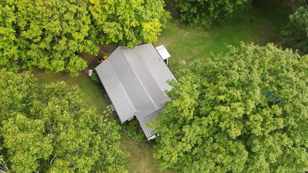 Silver classic panel metal roof on a wooded property in Centerville, Tennessee