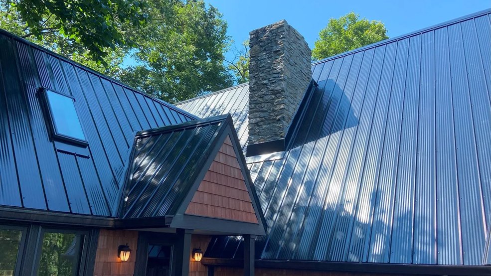 Front view of a black classic panel metal roof on a mid century cabin in Fairview, TN