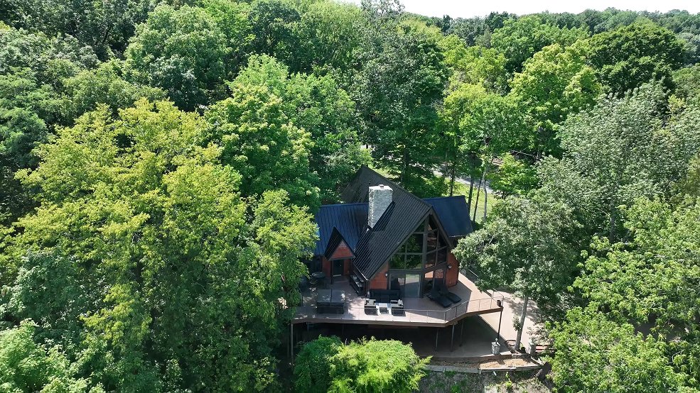Black classic panel metal roof on a modern cabin surrounded by trees in Fairview, Tennessee