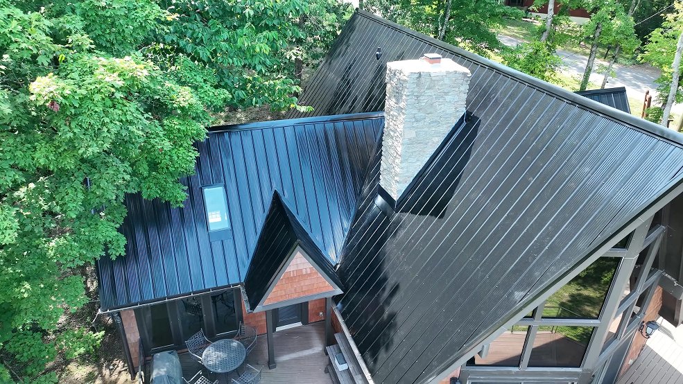 Black classic panel metal roof and overhang on a mid century cabin in Fairview, Tennessee