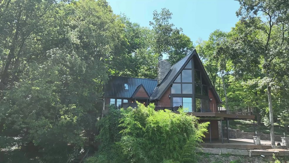 Black classic panel metal roof and rear elevation of a mid century cabin in Fairview, Tennessee